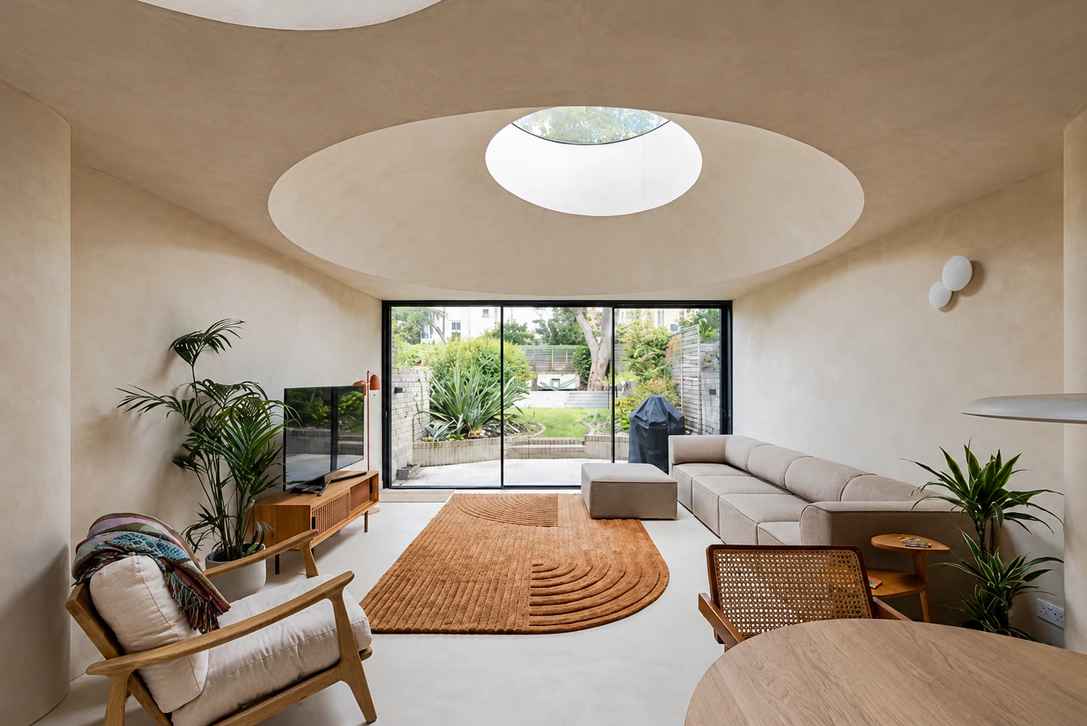 Living room with curved plaster ceiling, circular skylight and seamless pale floor